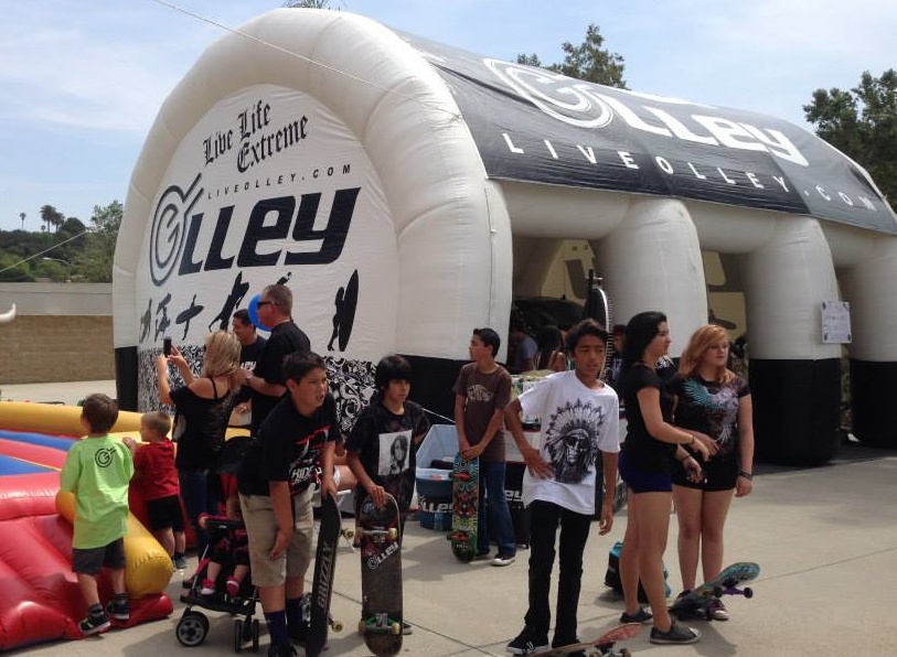 15x30 inflatable tent with printed tent top and wall panels for Olley with event attendees holding their skateboards around the tent