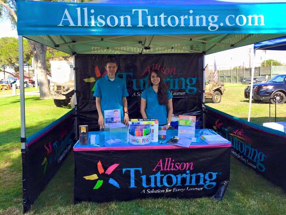 Allison Tutoring custom printed table cover, canopy, back wall, and short walls at an event on a grassy field