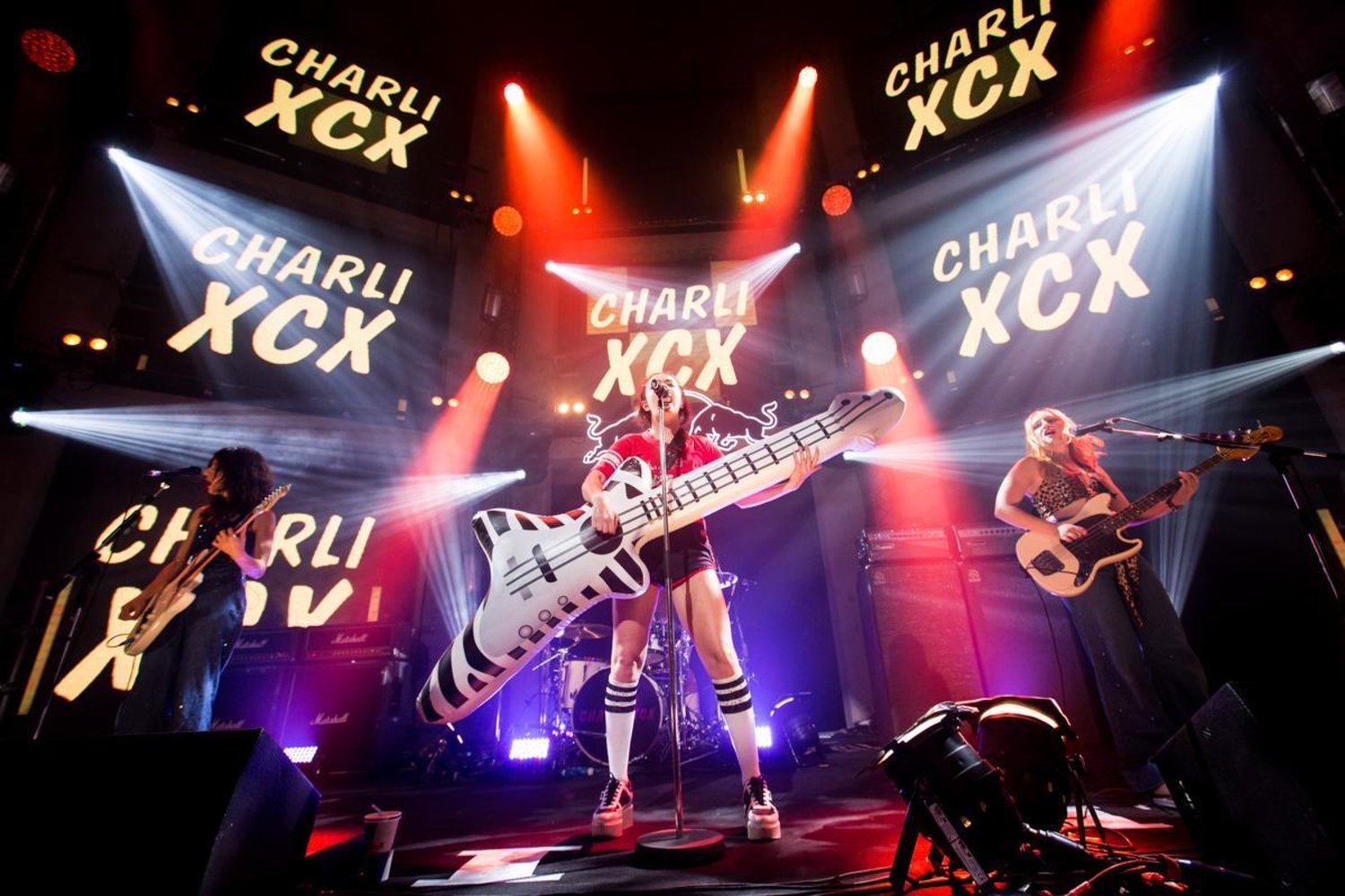 Charli xcx concert inflatable guitar prop being used by the lead singer