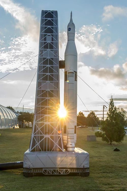 Inflatable NASA space rocket and launch tower with a beam of sunlight emerging from in between the tower and the rocket