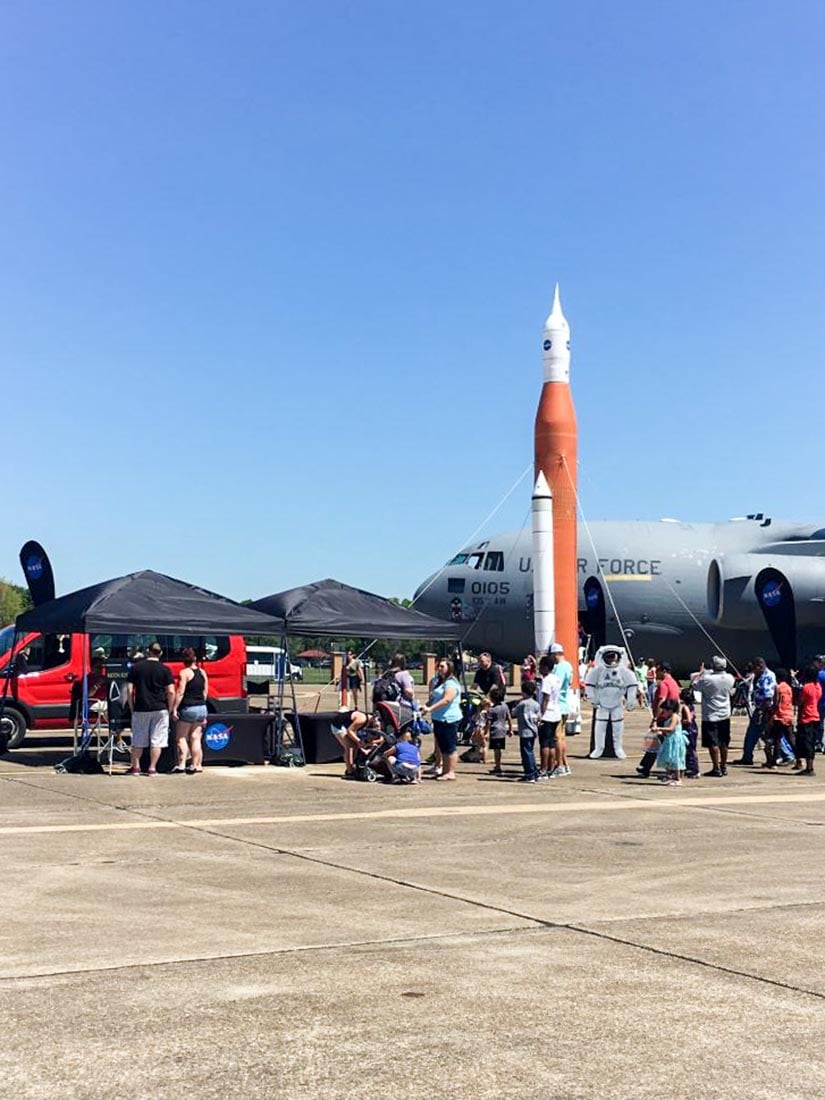 inflatable NASA rocket replica next to an air force air-craft