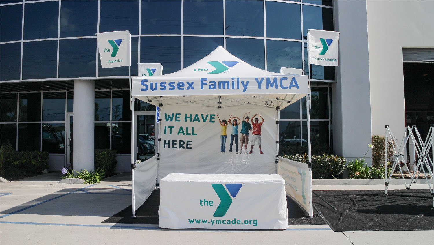Customized canopy with tent flags on all four corners, printed with the YMCA logo