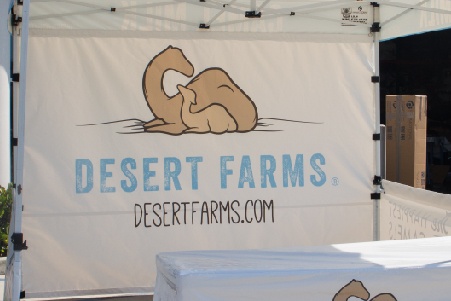 Desert Farms custom printed full back wall with a set of camels above the Desert Farms logo