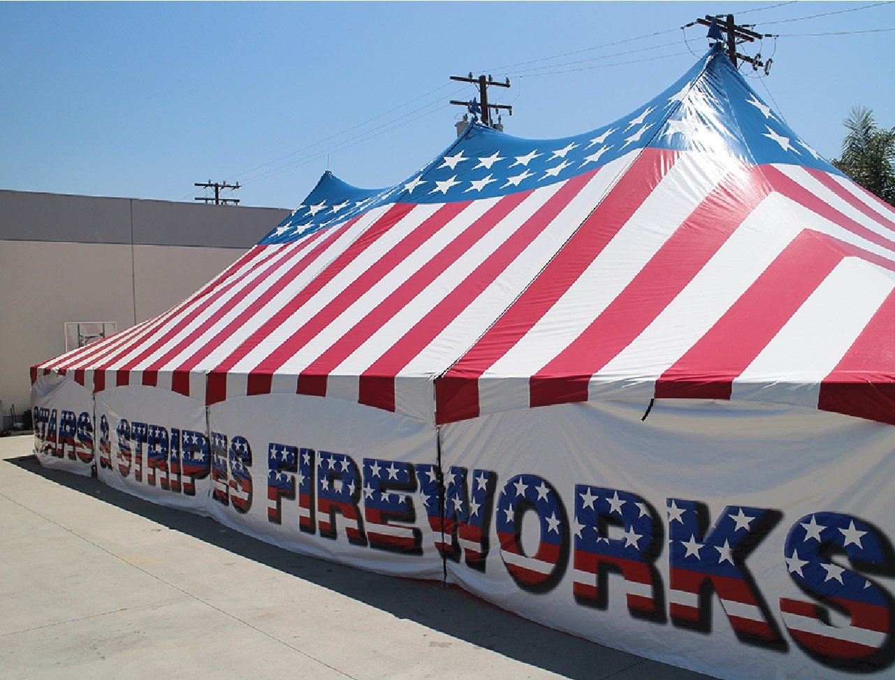 Stars and Stripes USA Patriotic Triple High Peak Frame Tent with stars and straps fireworks printed all across the side of the visible wall