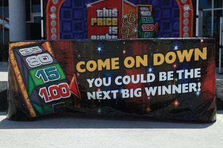 table cover in front of tent with the price is right slogans printed on the front panel of the 
