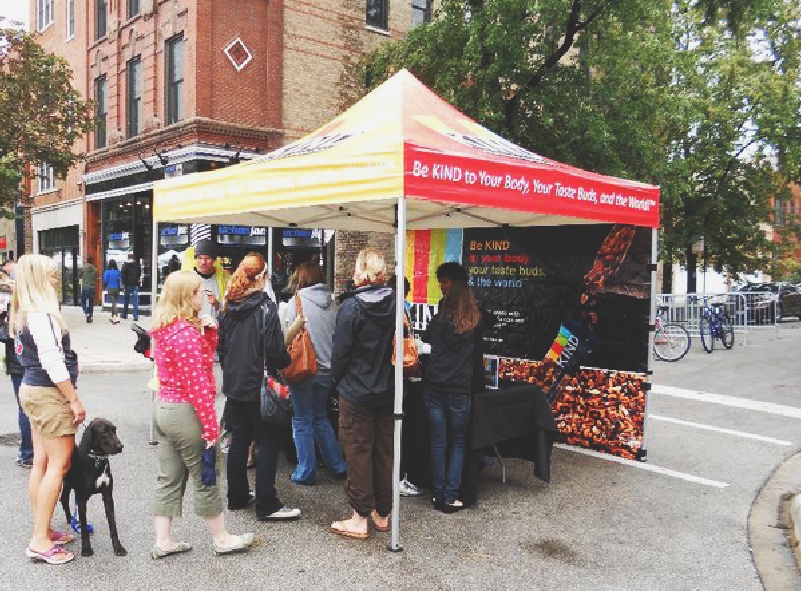 Be Kind custom printed canopy tent top and full back wall with people flocking around it at a shop
