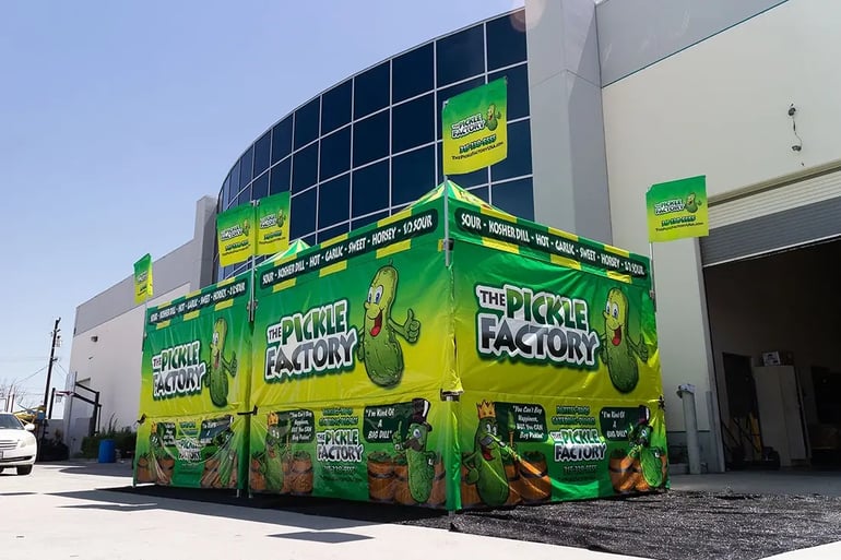 Side view of The Pickle Factory pop up canopy booth with full printed walls and corner flags