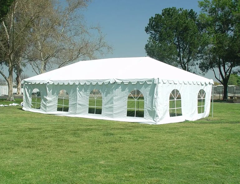 20x40 white frame tent rental with sidewalls and window panels set up on grass for an outdoor event