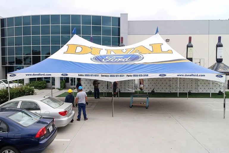 High peak event tent with Duval Ford roof logo and valance printing shown during setup