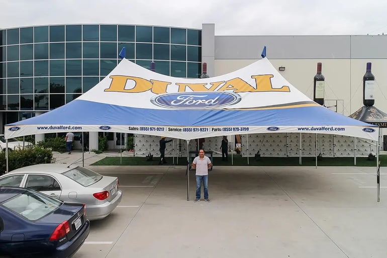 Large high peak event tent with Duval Ford roof branding and printed valance contact information