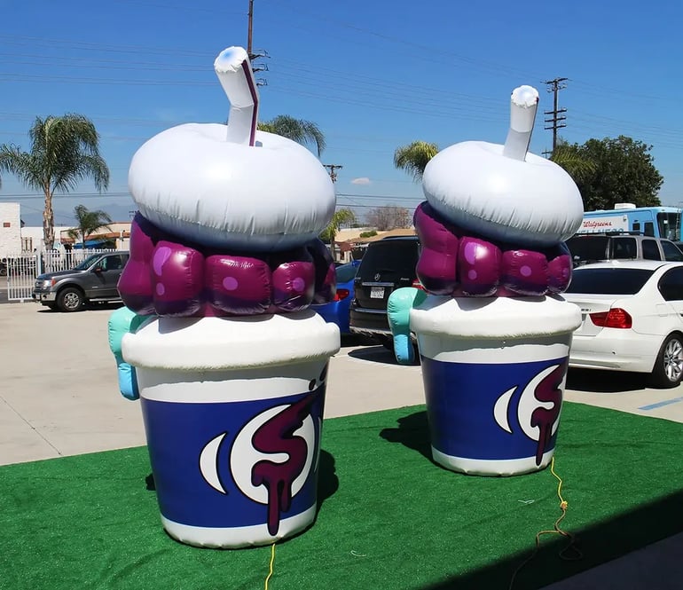 Pair of giant inflatable slush cup replicas used as a branded outdoor event display
