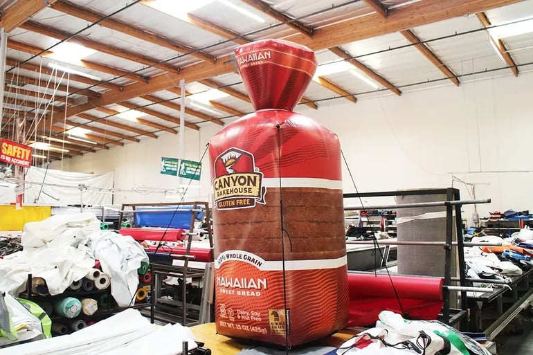 Custom inflatable bread loaf replica with Canyon Bakehouse branding displayed in the production shop
