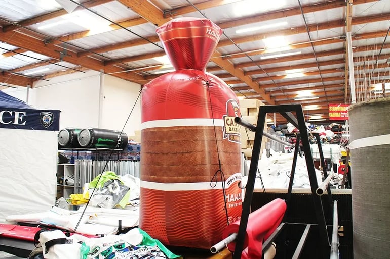 Back view of a custom inflatable bread loaf replica showing full-wrap print and product shape detail