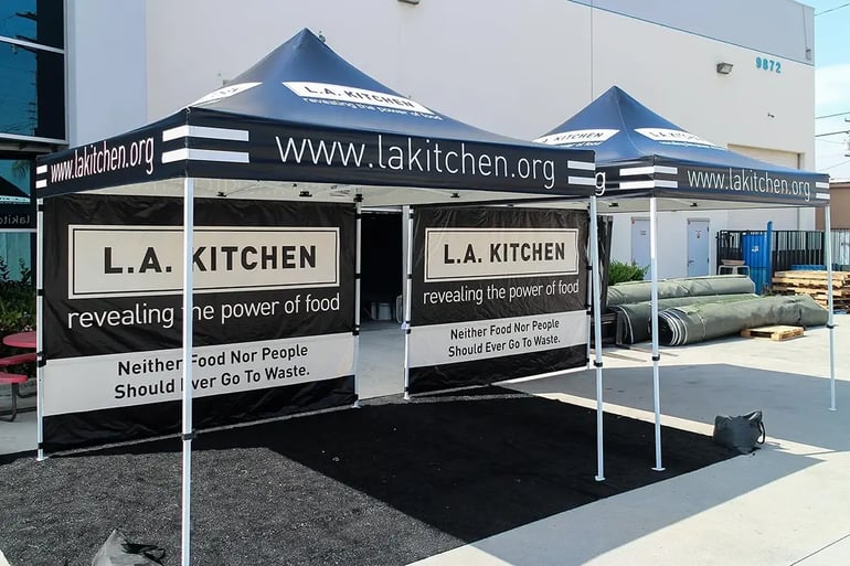 Two L.A. Kitchen branded 10x10 pop up canopies with printed walls for event setup