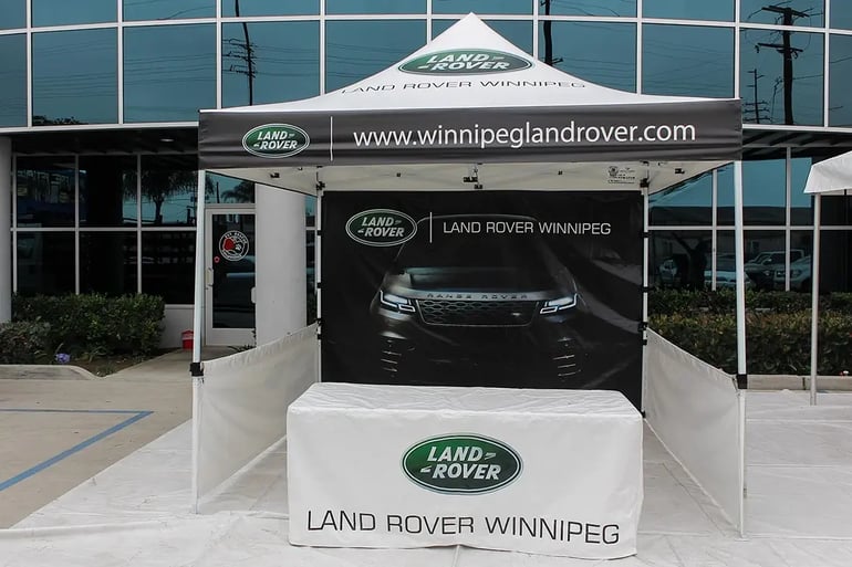 Branded 10x10 pop up canopy booth with printed back wall and Land Rover table cover