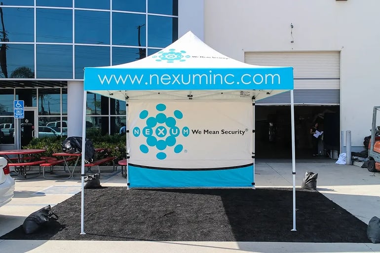 Branded 10x10 pop up canopy with Nexum Inc website valance and printed back wall graphic