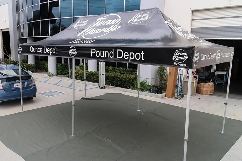 Branded pop up canopy with printed roof and valance logos for Team Charlie Pound Depot events
