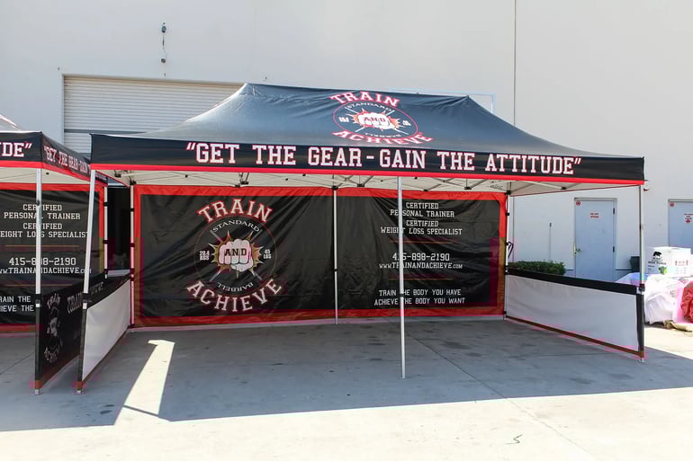 Extended pop up canopy booth with printed back wall and short side walls for fitness promotions