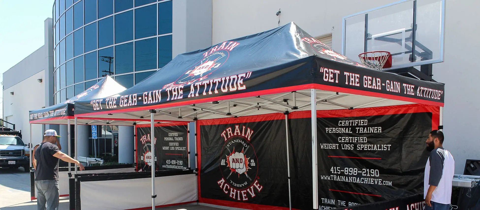10x20 pop up canopy booth with Train and Achieve branding and full printed back wall panels