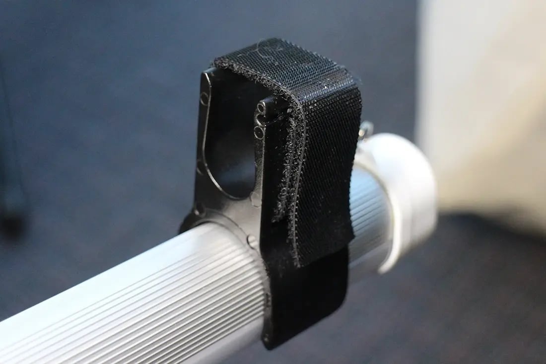 Close-up of LED canopy light mounting strap attached to a pop up canopy frame