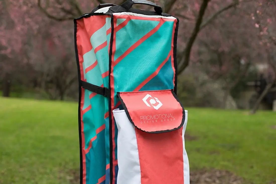 Custom printed pop up tent roller bag standing upright outdoors for easy transport and storage