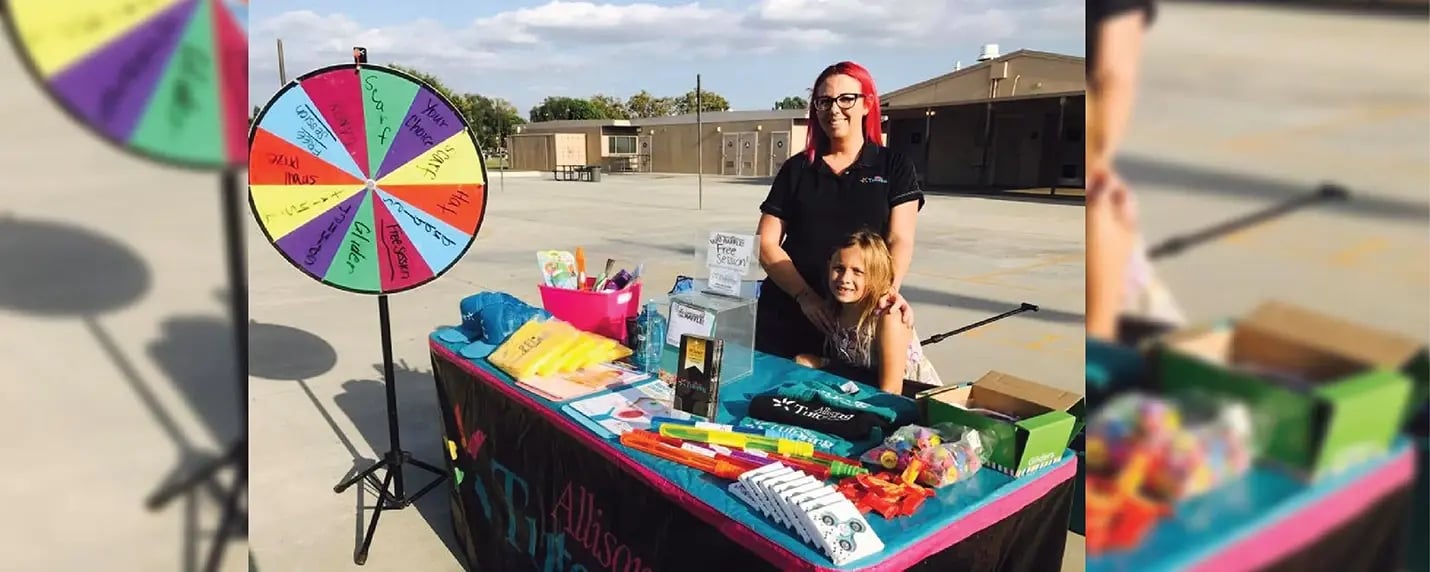 Event promo table with a branded table cover, prize wheel, and giveaway items for outreach or marketing.