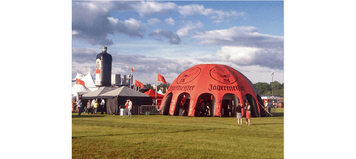 Inflatable event dome and giant bottle display used as a branded outdoor festival activation Inflatable event dome and giant bottle display used as a branded outdoor festival activation